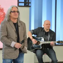Mężczyzna z mikrofonem i długimi włosami, obok gitarzysty. Może to być scena z wykonania "perfect kołysanka dla nieznajomej lyrics".