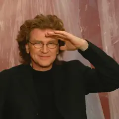 Zbigniew Wodecki w czarnym garniturze, z dłonią na czole, jakby szukał drogi, niczym w tekście "Lubię wracać tam, gdzie byłem".