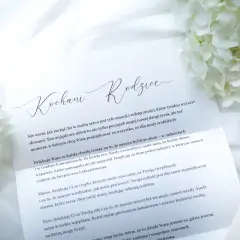 List z podziękowaniem dla rodziców na komunię, ozdobiony białymi kwiatami.