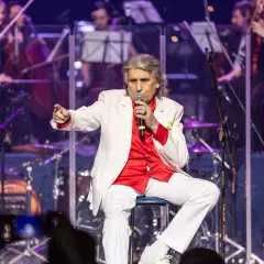 Toto Cutugno, w białej marynarce i czerwonej koszuli, śpiewa "L'Italiano".