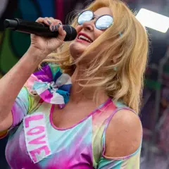Majka Jeżowska śpiewa "A ja wolę moją mamę", ubrana w kolorowy strój z napisem "LOVE".