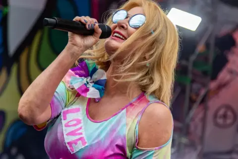 Majka Jeżowska śpiewa "A ja wolę moją mamę", ubrana w kolorowy strój z napisem "LOVE".