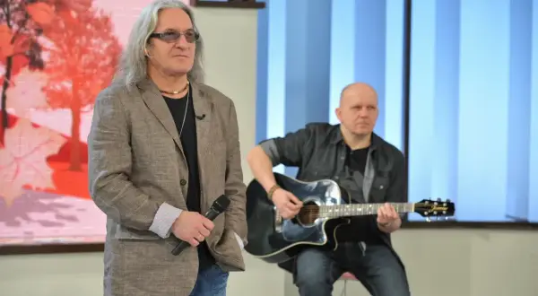 Mężczyzna z mikrofonem i długimi włosami, obok gitarzysty. Może to być scena z wykonania "perfect kołysanka dla nieznajomej lyrics".