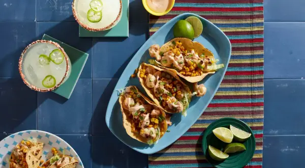 Tacos z kalafiorem i kukurydzą, margarity z papryczką jalapeno na niebieskim tle.