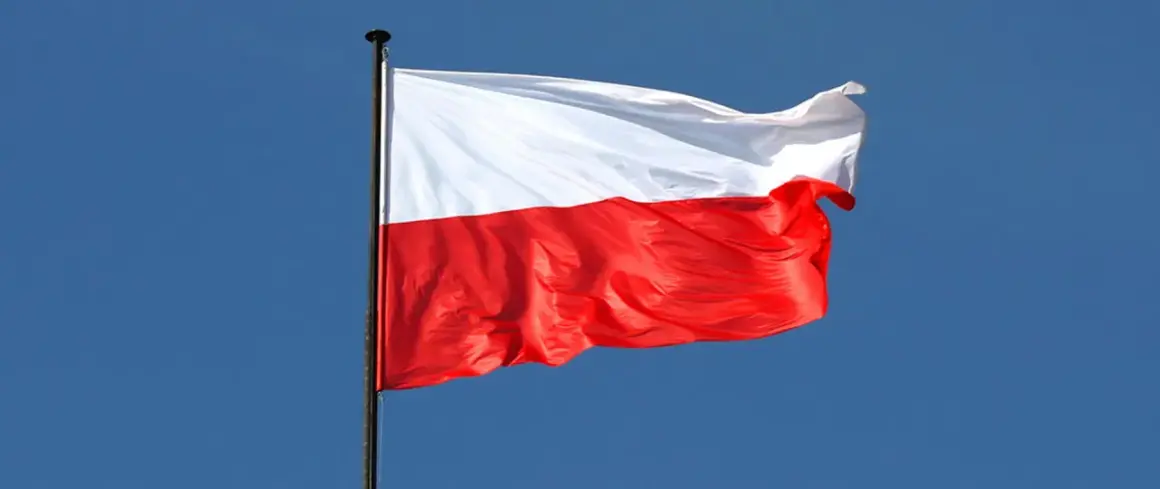 Biało-czerwona flaga Polski powiewa na wietrze. To symbol wolności, jak w piosence "Co to jest niepodległość tekst".