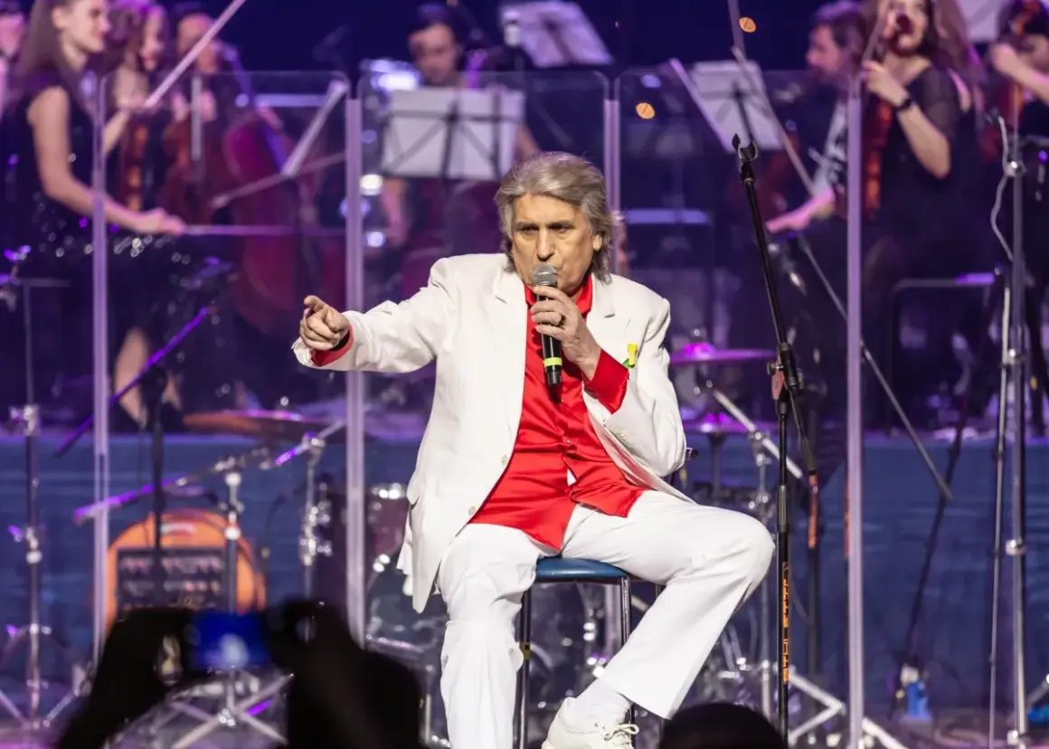Toto Cutugno, w białej marynarce i czerwonej koszuli, śpiewa "L'Italiano".