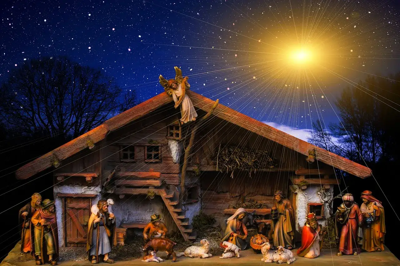 Szopka bożonarodzeniowa pod rozgwieżdżonym niebem. Anioł zwiastuje radosną nowinę, a pasterze i mędrcy oddają hołd. Holly jolly tłumaczenie tej sceny to radość i pokój.
